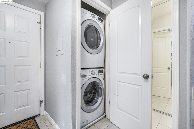 washroom with light tile patterned floors and stacked washer and clothes dryer