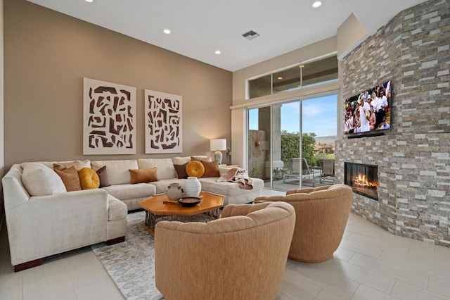 tiled living room with a stone fireplace