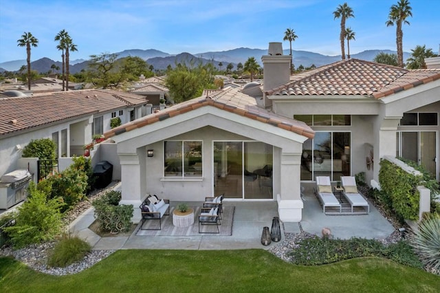 rear view of house with a mountain view and a patio area