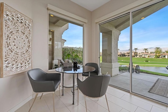 tiled dining area featuring a water view