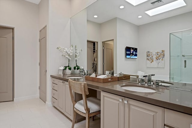 bathroom featuring vanity, tile patterned floors, a skylight, and a shower with door