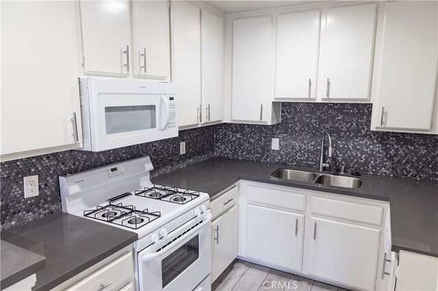 kitchen with sink, backsplash, white cabinets, and white appliances