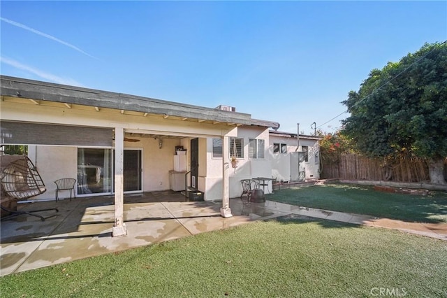 rear view of property featuring a yard and a patio