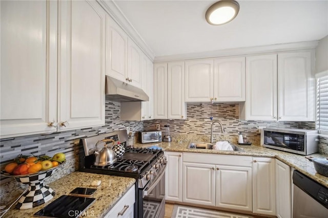 kitchen with white cabinets, sink, appliances with stainless steel finishes, tasteful backsplash, and light stone counters