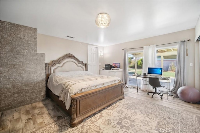 bedroom with access to exterior and light hardwood / wood-style floors