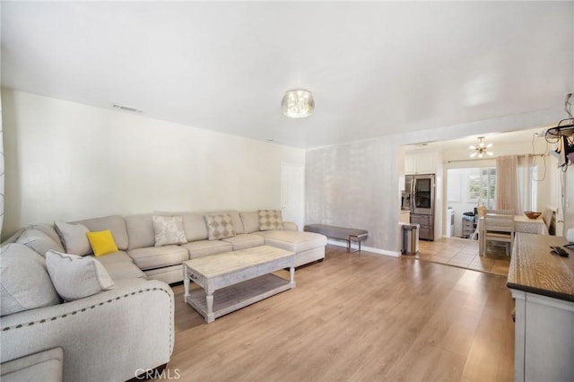 living room with a chandelier and light hardwood / wood-style flooring