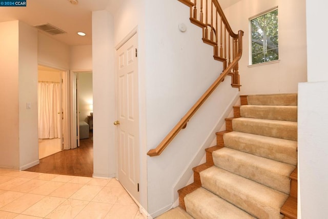 staircase featuring tile patterned flooring