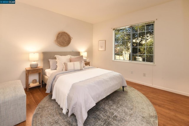 bedroom with dark hardwood / wood-style flooring