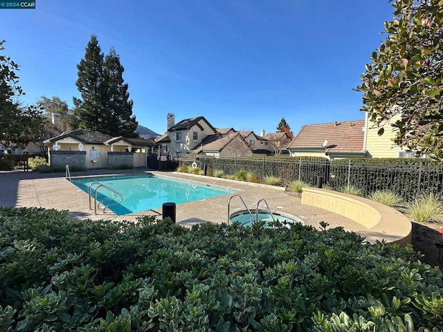 view of swimming pool with a patio area and a community hot tub