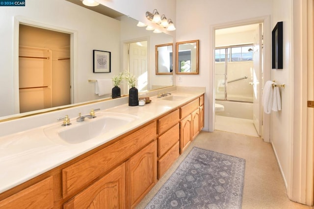 full bathroom featuring combined bath / shower with glass door, vanity, and toilet