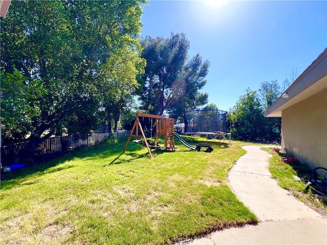 view of yard featuring a playground and a trampoline