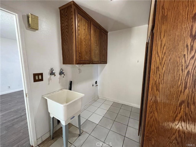 washroom featuring cabinets, washer hookup, and light tile patterned flooring