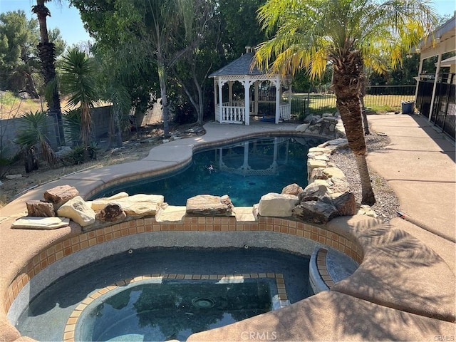 view of swimming pool featuring an in ground hot tub and a gazebo