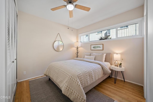 bedroom with hardwood / wood-style flooring, ceiling fan, and a closet