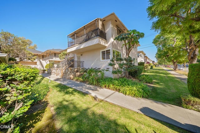 exterior space with a lawn and a balcony