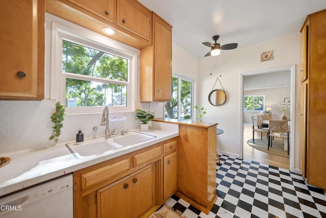 kitchen with ceiling fan, sink, backsplash, white dishwasher, and light hardwood / wood-style floors