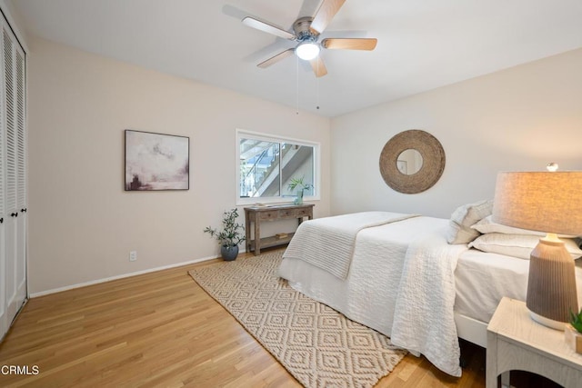 bedroom with ceiling fan, a closet, and light hardwood / wood-style floors