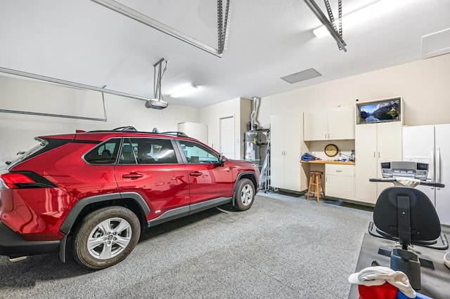 garage featuring secured water heater and a garage door opener