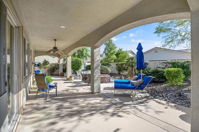 view of patio with ceiling fan and a fire pit