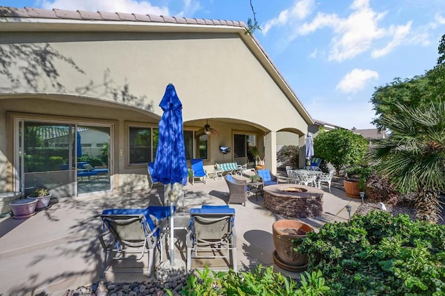 view of patio with ceiling fan and a fire pit