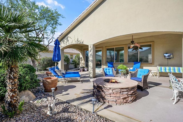 view of patio / terrace featuring ceiling fan and a fire pit