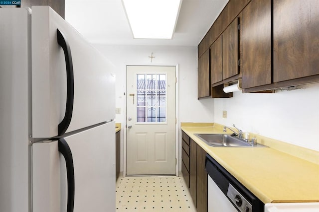 kitchen featuring dark brown cabinetry, dishwasher, white fridge, and sink