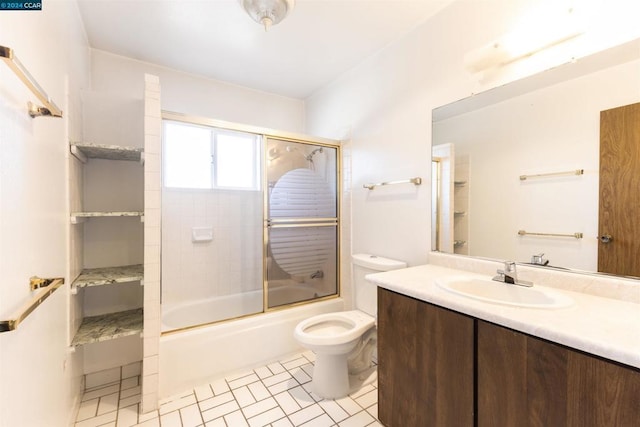 full bathroom featuring tile patterned flooring, vanity, bath / shower combo with glass door, and toilet