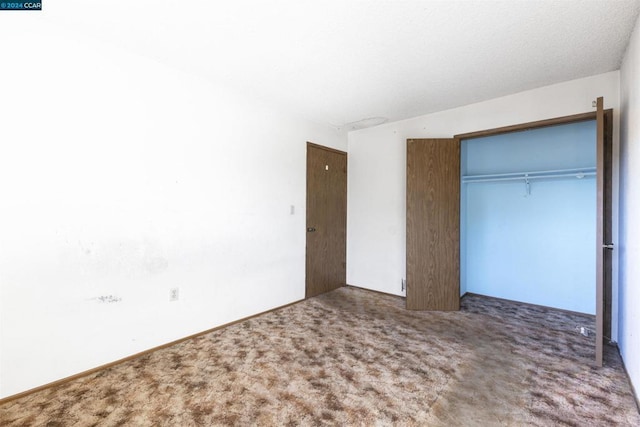 unfurnished bedroom featuring a closet and carpet floors