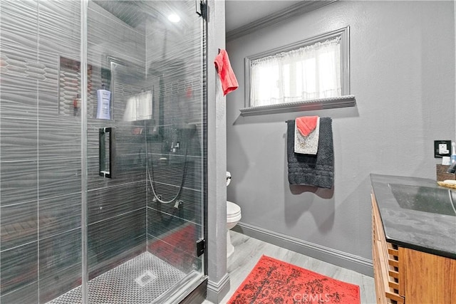 bathroom featuring walk in shower, ornamental molding, vanity, hardwood / wood-style flooring, and toilet