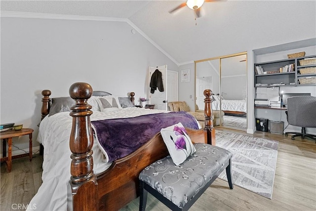 bedroom featuring light wood-type flooring, ornamental molding, vaulted ceiling, ceiling fan, and a closet