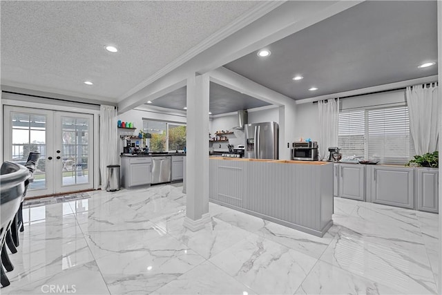 kitchen with wooden counters, appliances with stainless steel finishes, a textured ceiling, and french doors