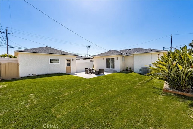 rear view of property with central AC unit, a patio area, and a lawn