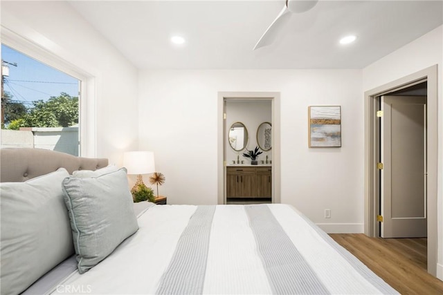 bedroom featuring ensuite bathroom, hardwood / wood-style floors, and ceiling fan