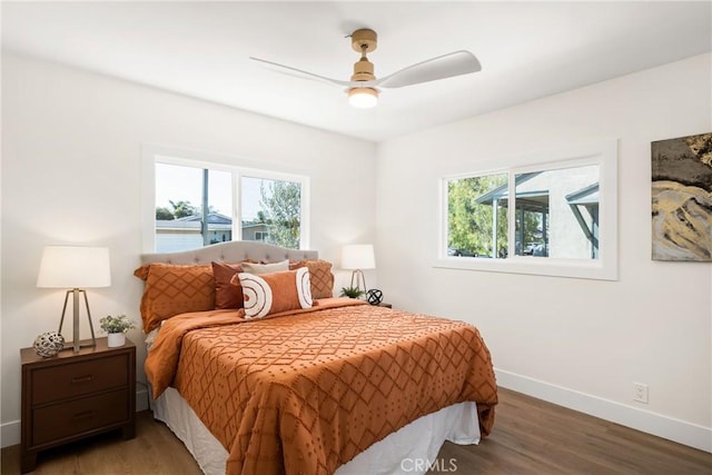 bedroom featuring multiple windows, hardwood / wood-style flooring, and ceiling fan