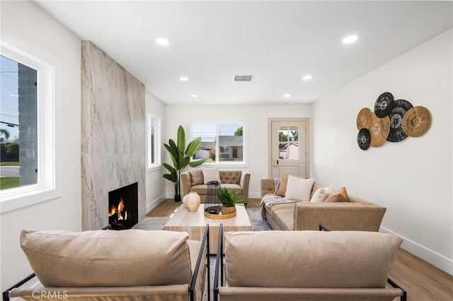 living room with light hardwood / wood-style flooring and a premium fireplace