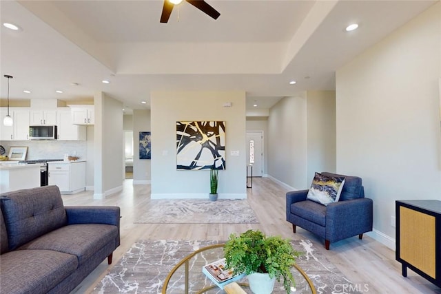 living room with light wood-type flooring and ceiling fan