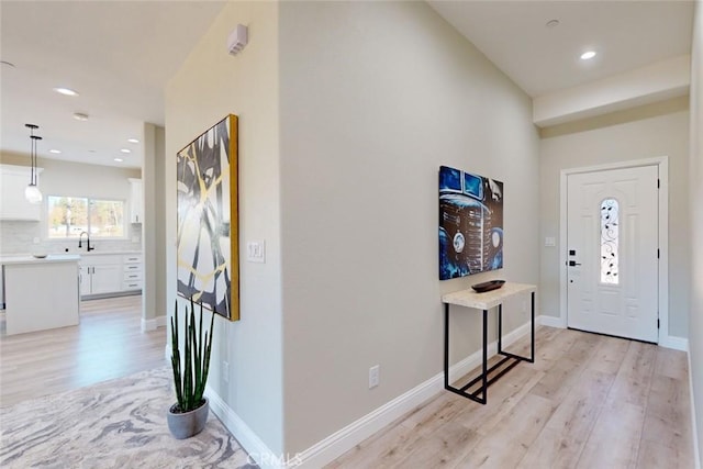 foyer entrance featuring light wood-type flooring and sink