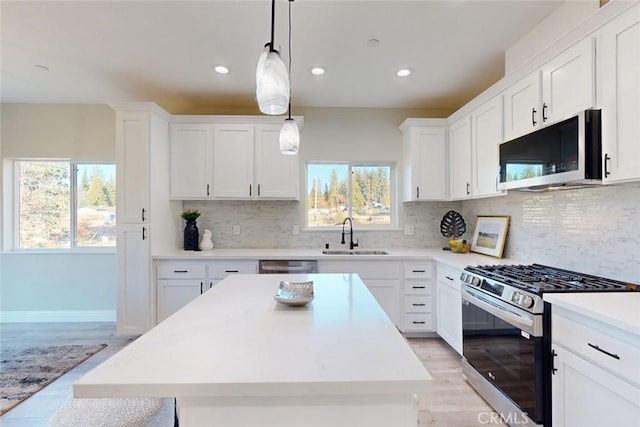 kitchen featuring decorative backsplash, stainless steel appliances, plenty of natural light, and sink