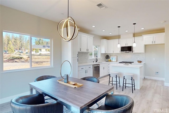 dining area with light hardwood / wood-style floors and sink