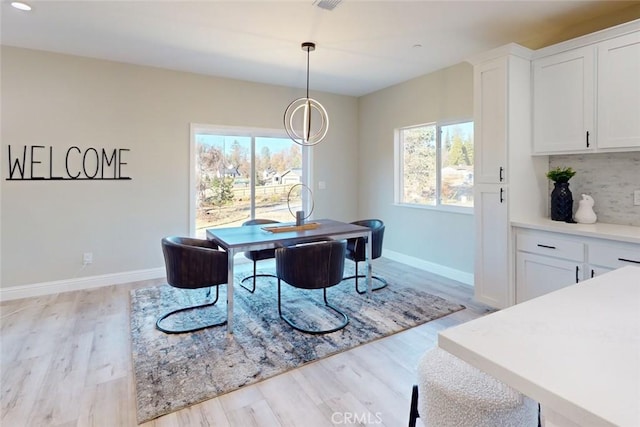 dining space featuring light hardwood / wood-style floors and a chandelier