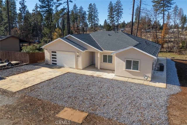 single story home with a garage and central AC unit