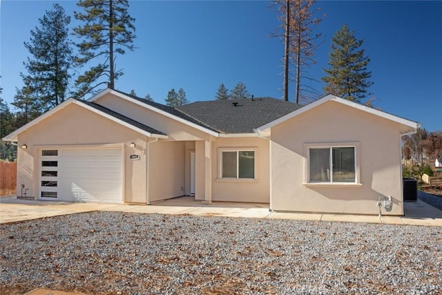 rear view of house with central AC unit and a garage