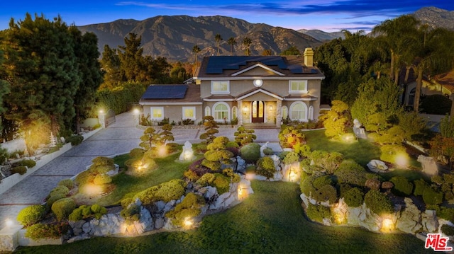 view of front of home with a mountain view and solar panels