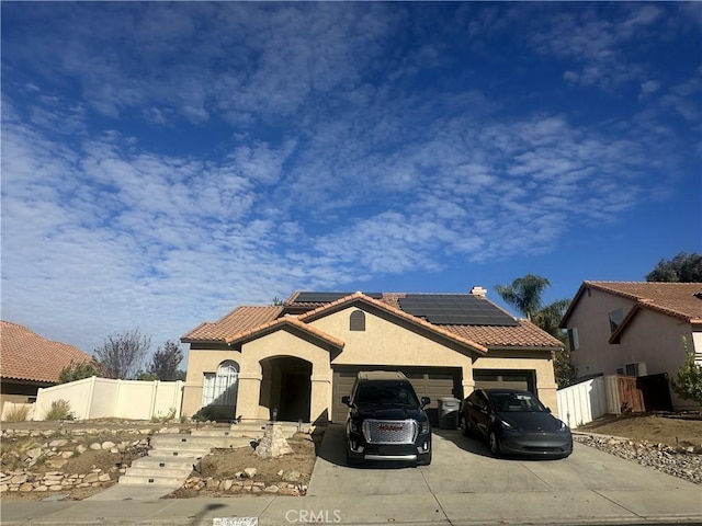 mediterranean / spanish home featuring a garage and solar panels