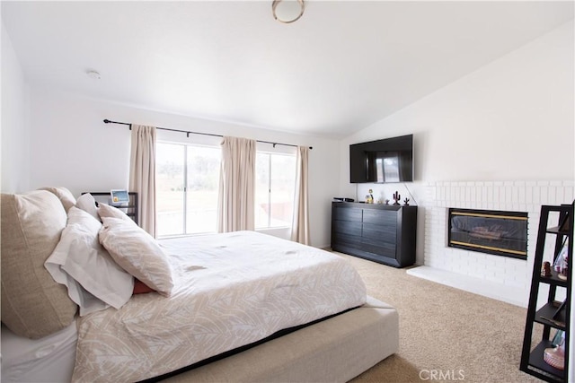 bedroom with light carpet, a fireplace, and lofted ceiling