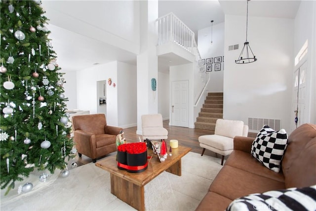 living room featuring a high ceiling and light hardwood / wood-style floors