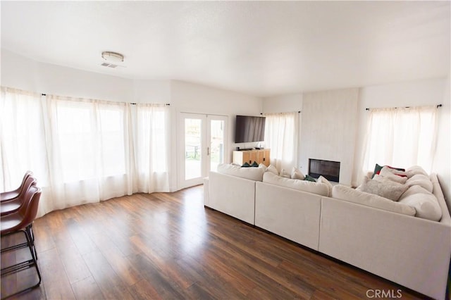 unfurnished living room with dark wood-type flooring and french doors