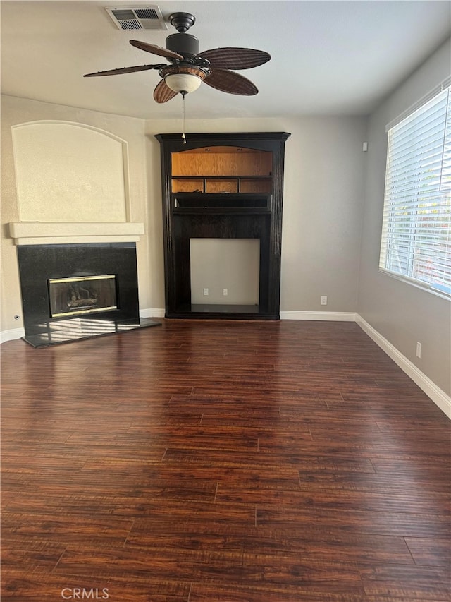 unfurnished living room featuring ceiling fan and dark wood-type flooring