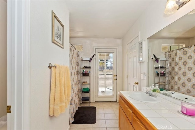 bathroom with tile patterned flooring, vanity, and walk in shower