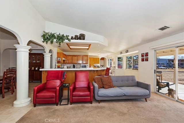 tiled living room featuring ornate columns and lofted ceiling